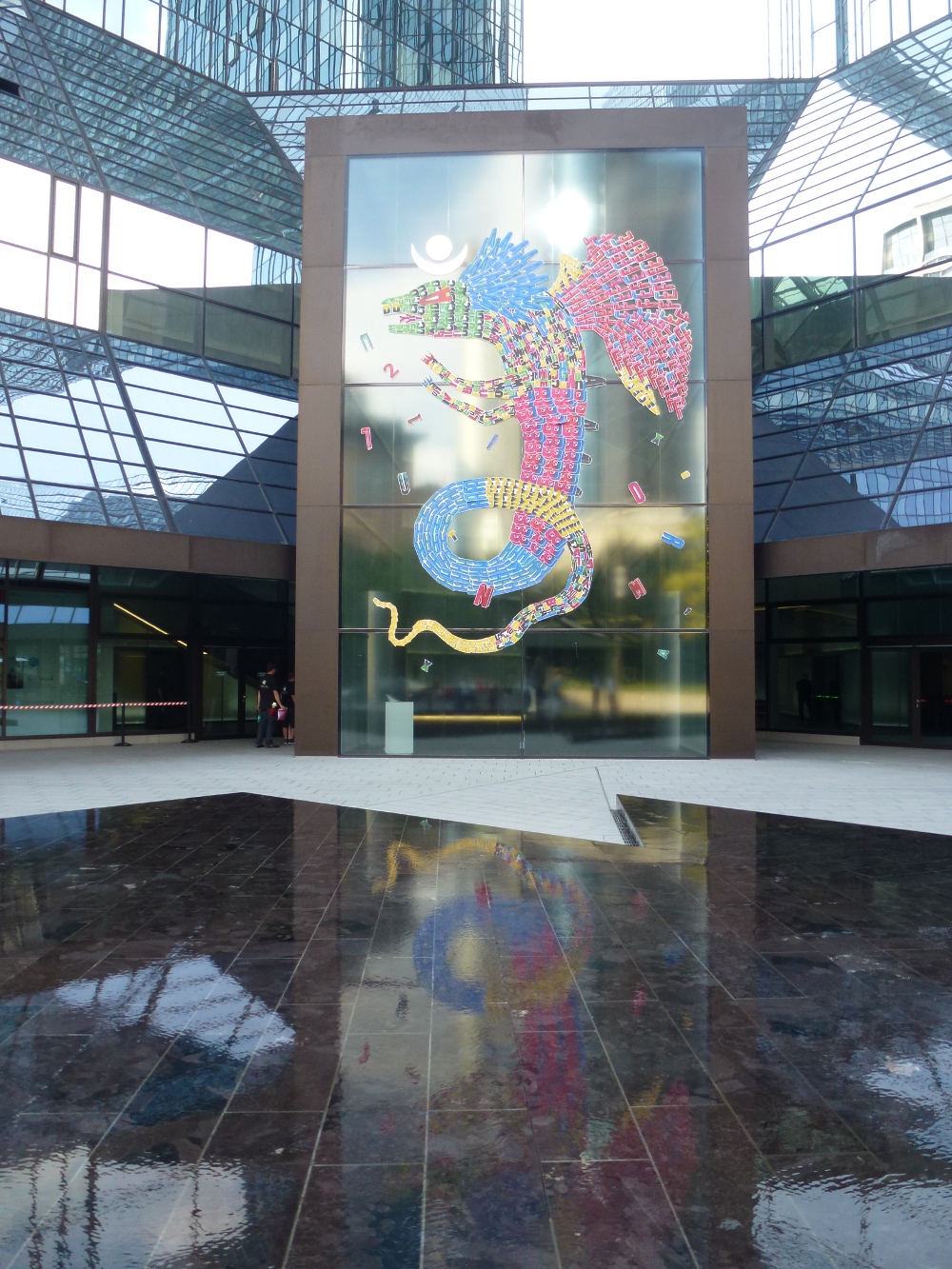 farbenprächtigen „Alebrijes - die traditionellen Monster-paintings von Fefe Talavera mit Spiegelung im Brunnen vor der Gebäude der Deutschen Bank in Frankfurt am Main